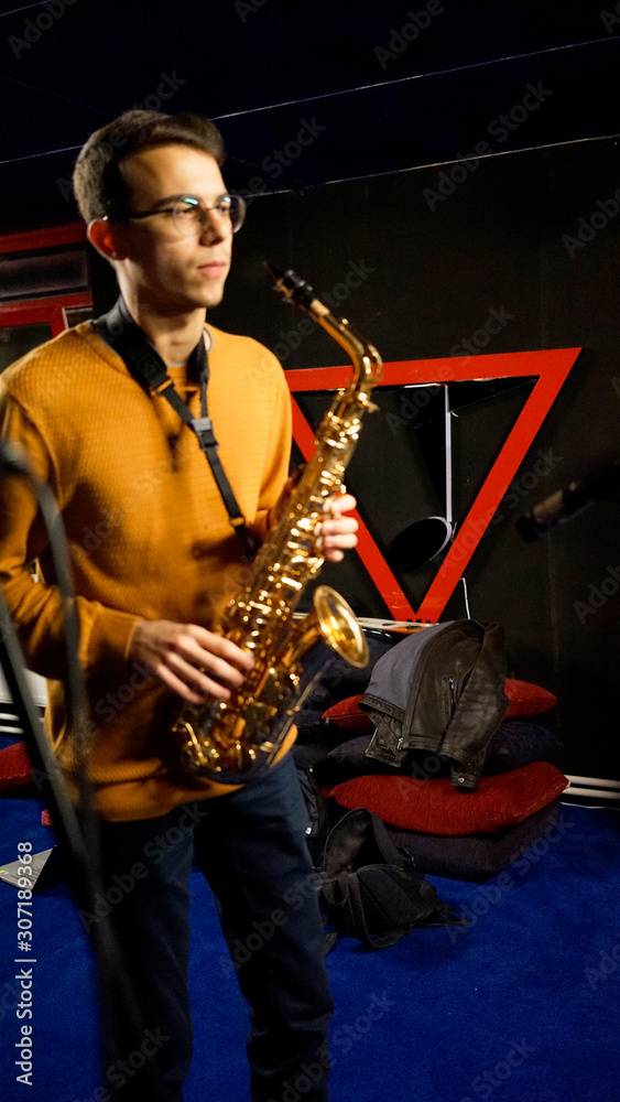 Naklejka premium young man playing the saxophone