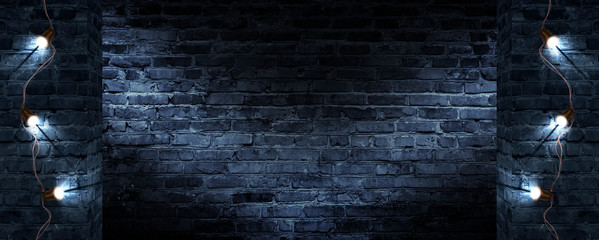 Dark street, old brick wall decorated with night lanterns. Empty street scene, neon light. Night view, blurred abstract bokeh light.