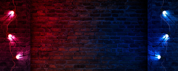 Dark street, old brick wall decorated with night lanterns. Empty street scene, neon light. Night view, blurred abstract bokeh light.