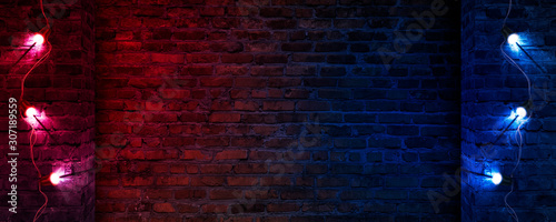 Dark street, old brick wall decorated with night lanterns. Empty street scene, neon light. Night view, blurred abstract bokeh light.