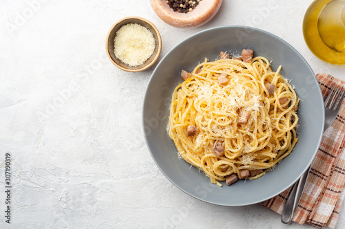 Classic spaghetti pasta carbonara with pancetta, egg yolk and parmesan cheese on concrete background. Top view, copy space. photo