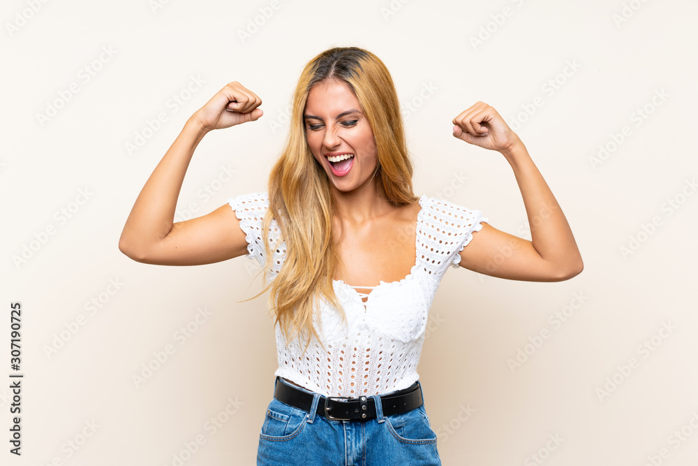 Young blonde woman over isolated background celebrating a victory Young blonde woman over isolated background celebrating a victory