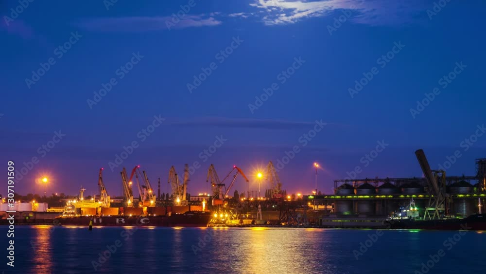 Cranes unload the ship's cargo hold timelapse at dawn Cranes unload the ship's cargo hold timelapse at dawn