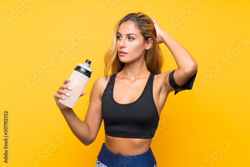 Young sport woman with a bottle of water over isolated background