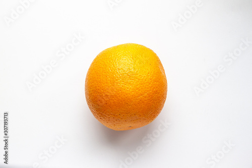 Single orange in the center on a white background, top view, flat lay