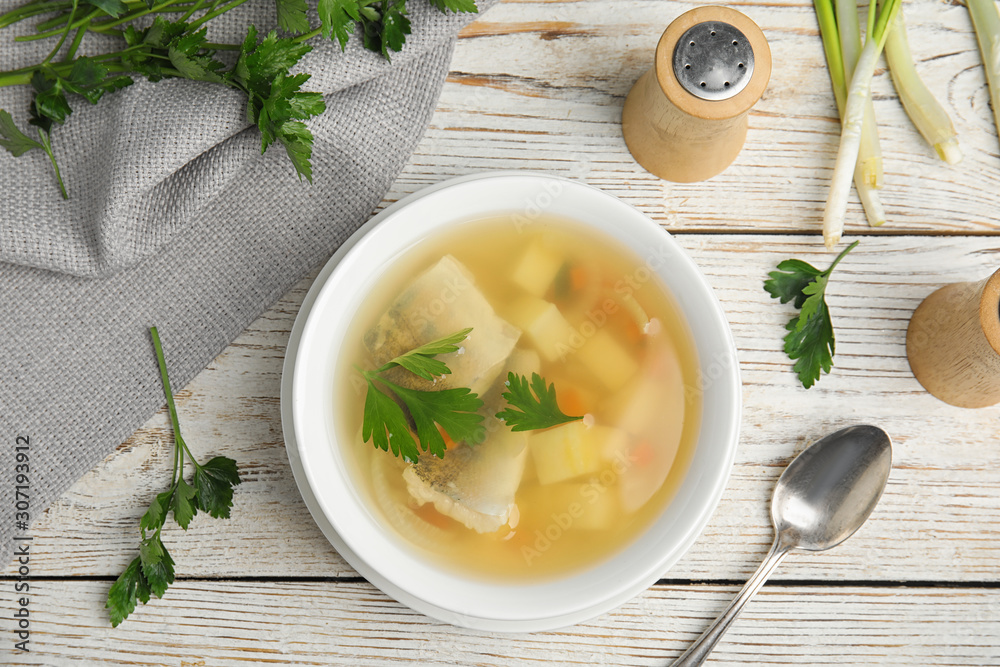 Delicious fish soup served on white wooden table, flat lay Delicious fish soup served on white wooden table, flat lay