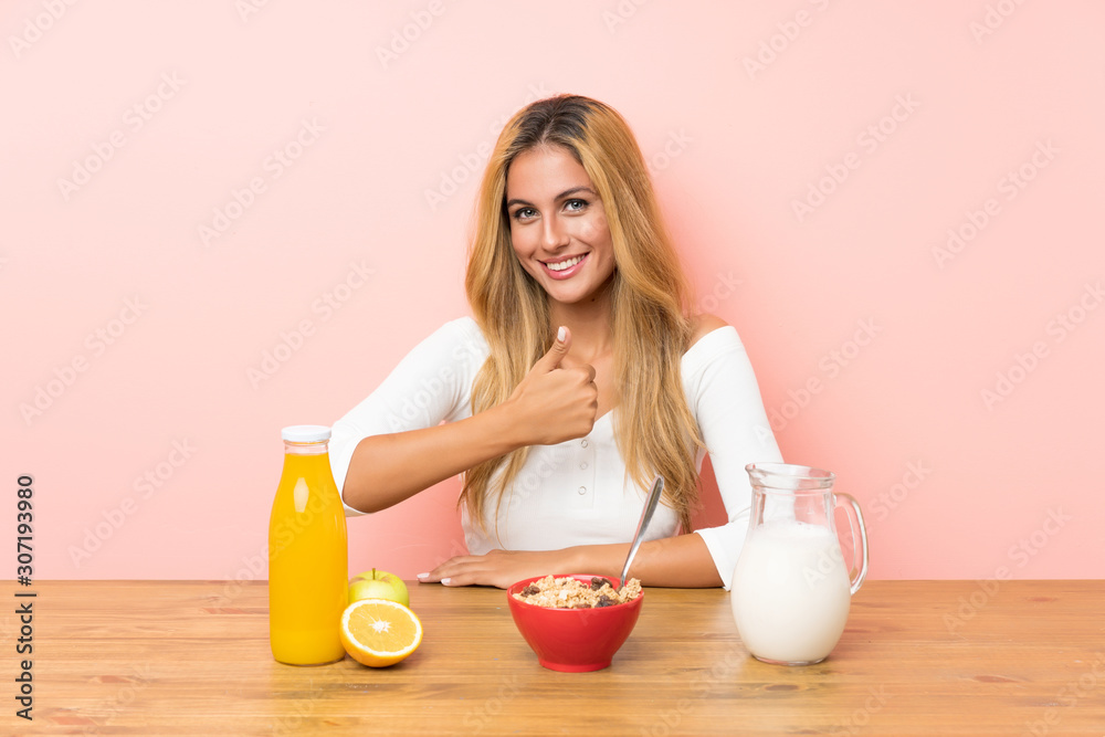 Young blonde woman having breakfast milk giving a thumbs up gesture Young blonde woman having breakfast milk giving a thumbs up gesture