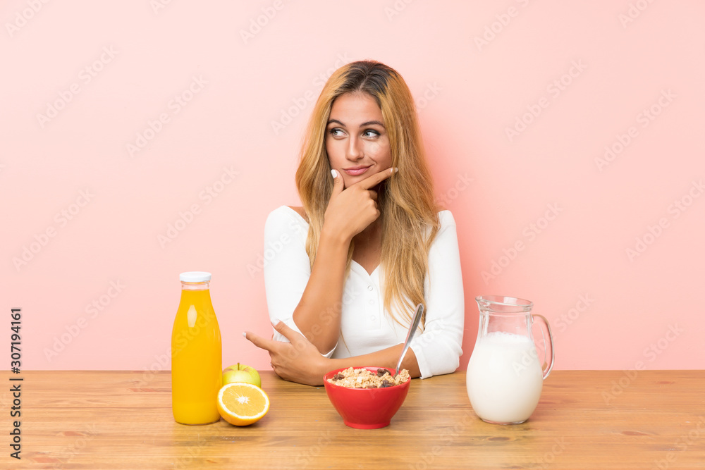 Young blonde woman having breakfast milk thinking an idea Young blonde woman having breakfast milk thinking an idea