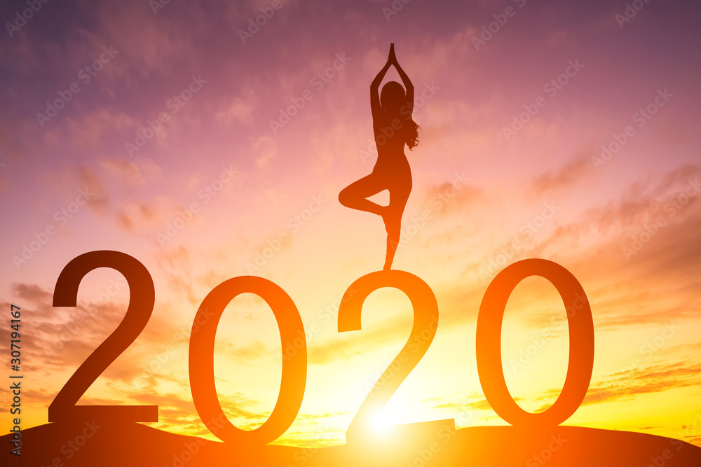 Happy New Year 2020, Silhouette woman practicing yoga early morning sunrise over the horizon background, Health and Happy new year concept. Happy New Year 2020, Silhouette woman practicing yoga early morning sunrise over the horizon background, Health and Happy new year concept.