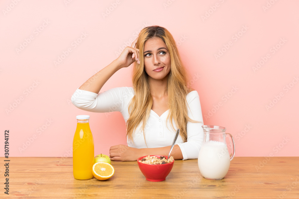 Young blonde woman having breakfast milk having doubts and with confuse face expression Young blonde woman having breakfast milk having doubts and with confuse face expression