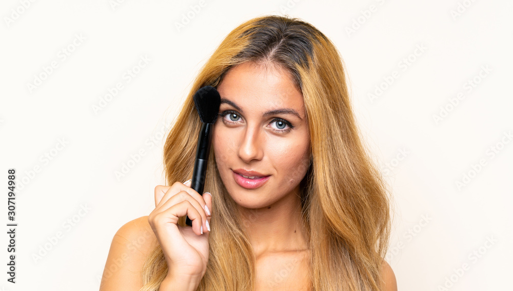 Young blonde woman with makeup brush Young blonde woman with makeup brush