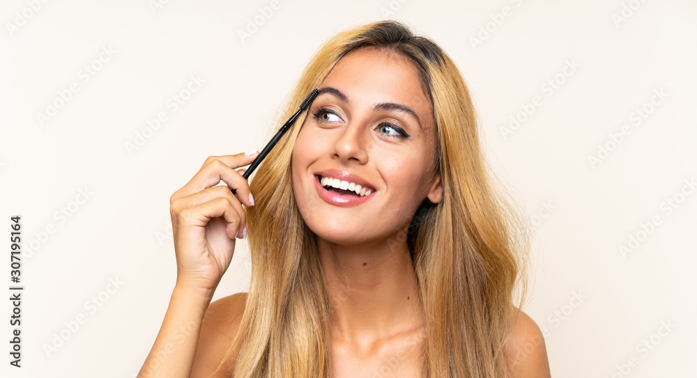 Young blonde woman applying mascara with cosmetic rush Young blonde woman applying mascara with cosmetic rush