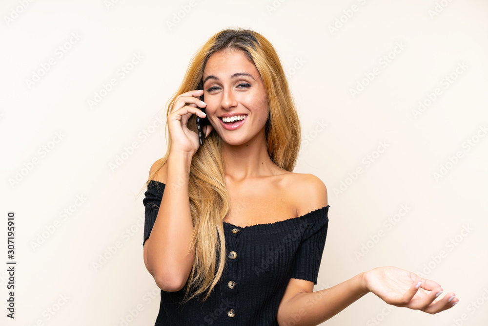 Young blonde woman with a mobile over isolated background Young blonde woman with a mobile over isolated background