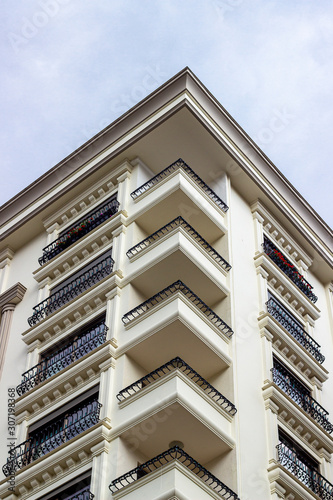 Bottom-up shoot of classical ecclectic style of mass housing facade corner with iron details