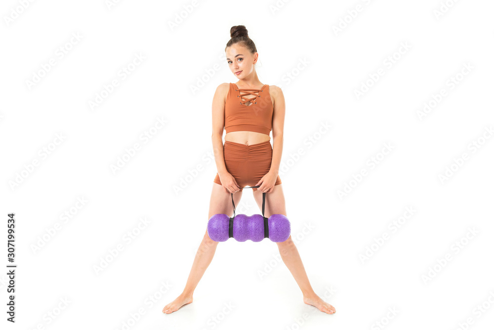 European brunette girl in a brown sports swimsuit with massage stands on a white background