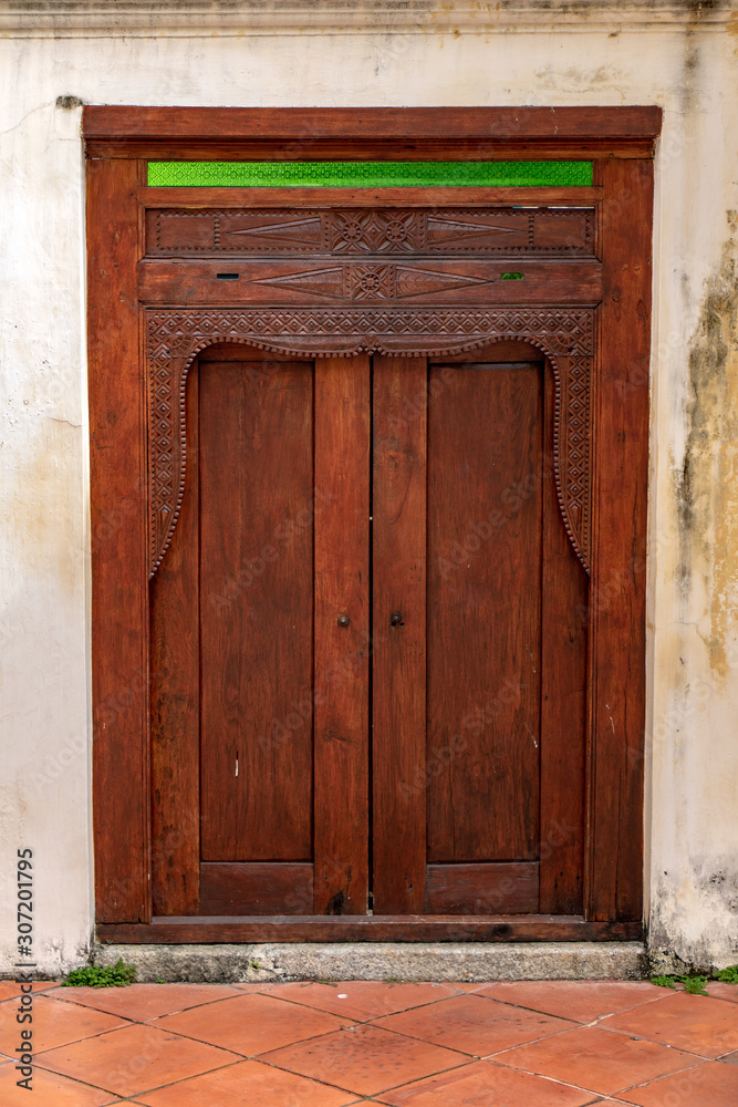 An decorative door with white facade of house, Penang, Malaysia.