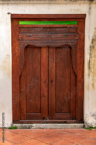 An decorative door with white facade of house  Penang  Malaysia.