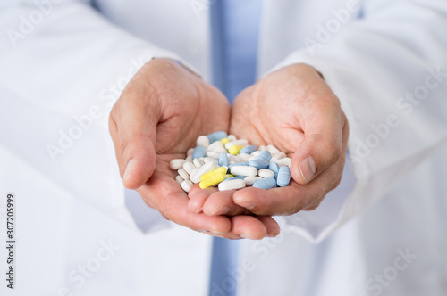 Closeup shot of an unidentifiable male doctor holding a variety of pills in her hands