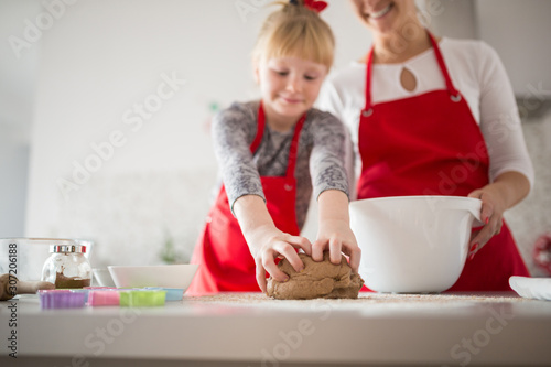 Young happy girl learning how to knead dough