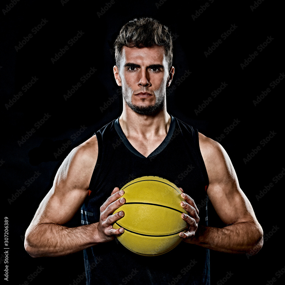 one caucasian young basketball player man in studio isolated on black background one caucasian young basketball player man in studio isolated on black background