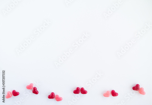 Valentines day card with tiny candy sweet hearts on white background. Flat lay, top view, copy space. 
