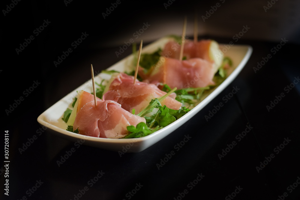 Italian antipasti mellon in parma ham served on elegant plate Italian antipasti mellon in parma ham served on elegant plate