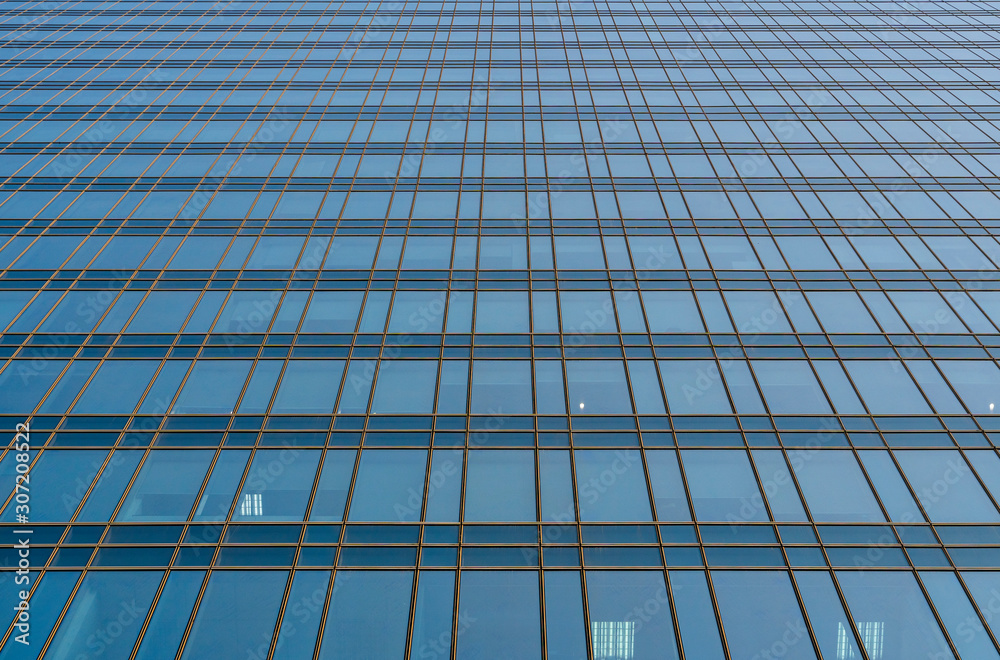 Reflection of the sky in the windows of a building. Perspective and underdite angle view to modern glass building skyscrapers over blue sky. Windows of Bussiness office or corporate building. Reflection of the sky in the windows of a building. Perspective and underdite angle view to modern glass building skyscrapers over blue sky. Windows of Bussiness office or corporate building.