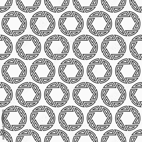 Abstract seamless pattern of repeating round striped circular ornaments.