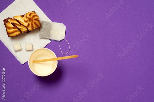 Paper cup, tea bag, sugar cubes and curd cake