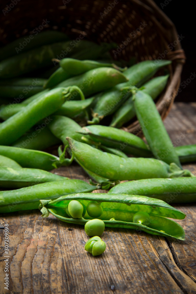 Green peas and peapods and basket Green peas and peapods and basket