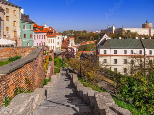 Beautiful autumn landscape of Lublin (Poland) with a castle on a hill. Colorful panorama of the town with colored houses, a stairs and motley trees
