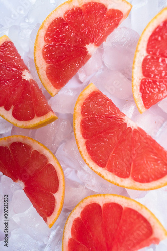 Slices of grapefruit on ice. Close-up.