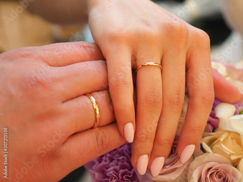 newlyweds hands with rings together closeup
