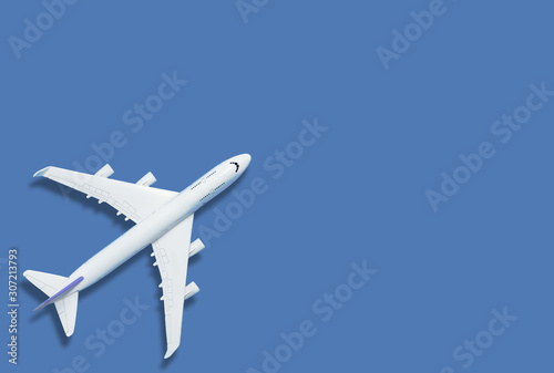 Flat lay of miniature toy airplane on blue background minimal trip and travel creative concepts. copy space