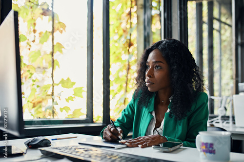 Businesswoman using graphics tablet at desk in office