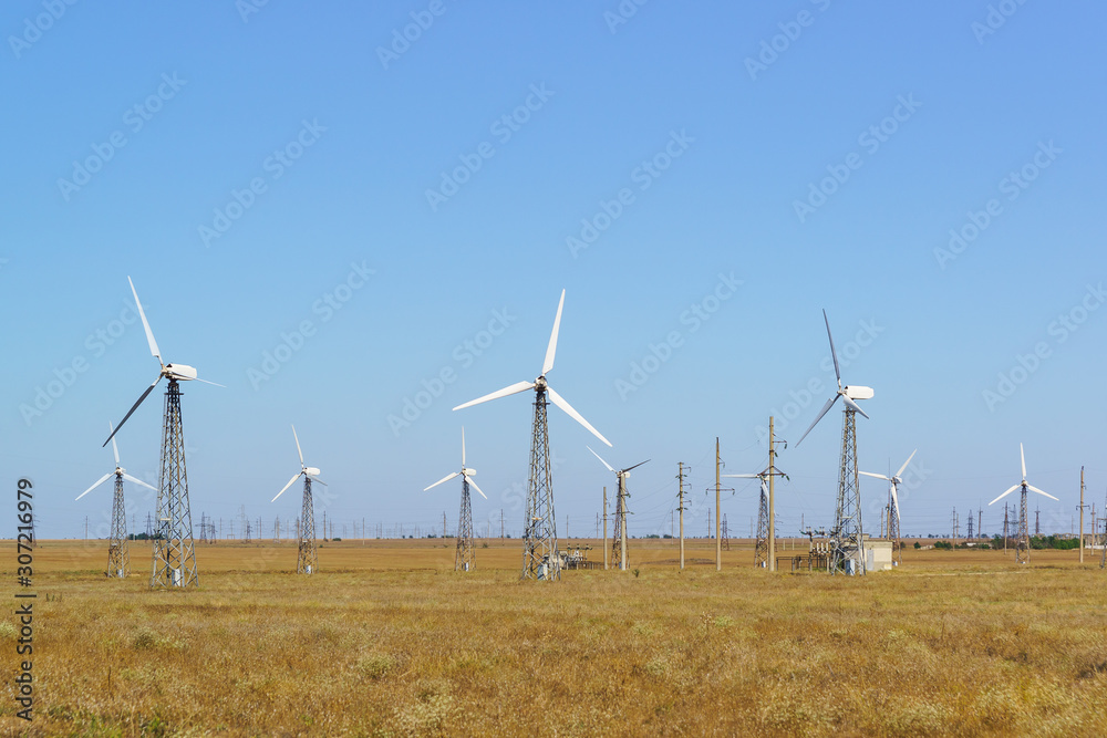 Lots of spinning wind turbines against a clear blue sky. Ground for alternative energy in the Crimea Lots of spinning wind turbines against a clear blue sky. Ground for alternative energy in the Crimea
