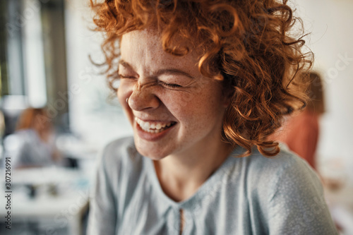 Portrait of a laughing businesswoman with closed eyes in office