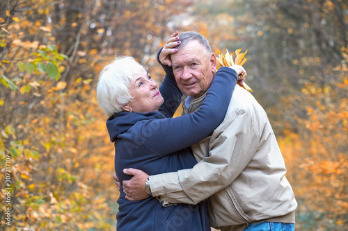 Senior man and woman hugging in an autumn park