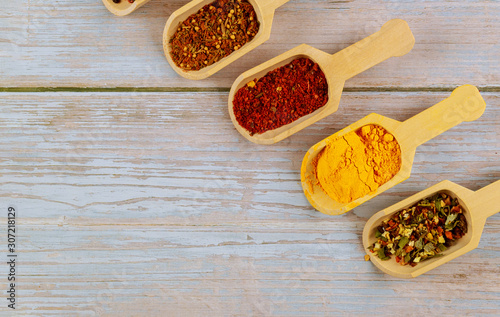 Fototapeta Naklejka Na Ścianę i Meble -  Wooden scoops of asian spices on white wooden table.