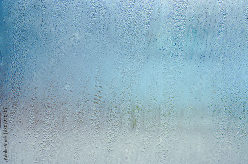 Indoor wet window on which droplets of water slide.