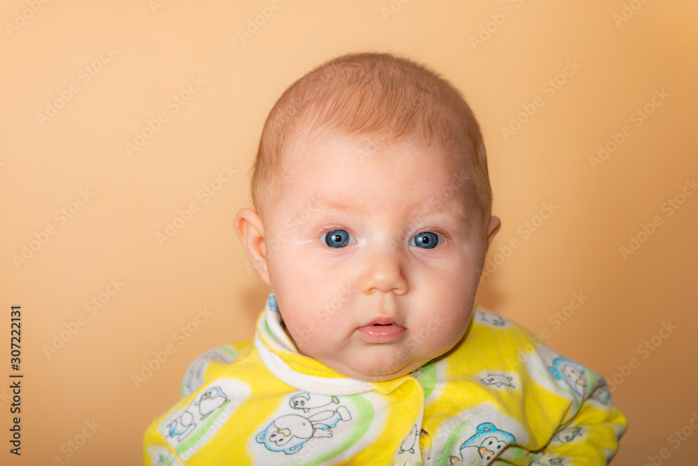 Portrait of a little girl looking at the camera on a beige background. Portrait of a little girl looking at the camera on a beige background.
