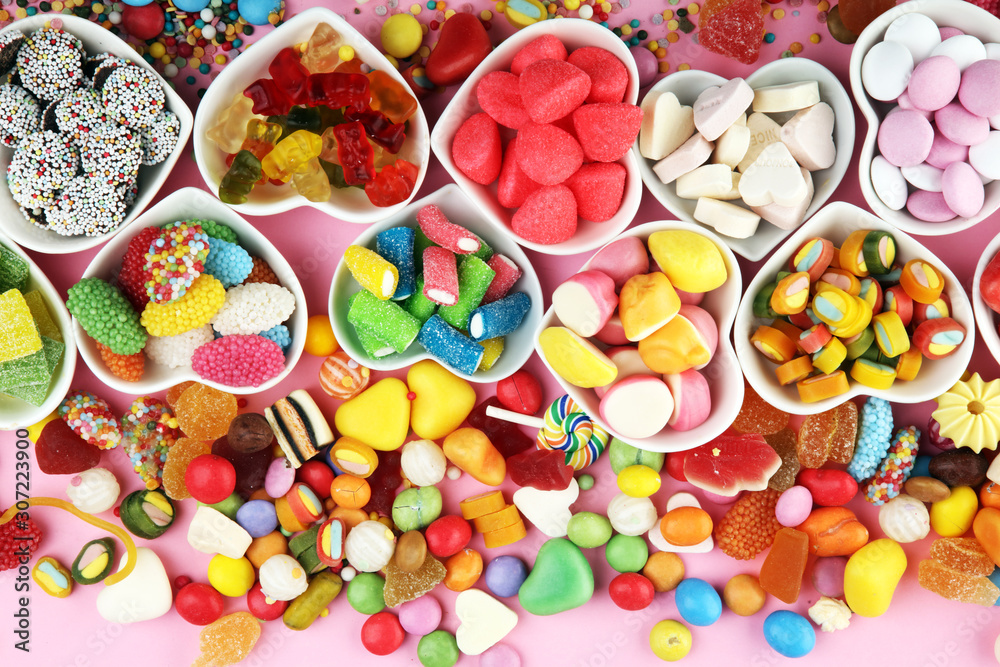 candies with jelly and sugar. colorful array of different childs sweets and treats on pink background candies with jelly and sugar. colorful array of different childs sweets and treats on pink background