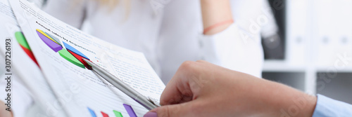 Group of people deliberate on problem with clipboard
