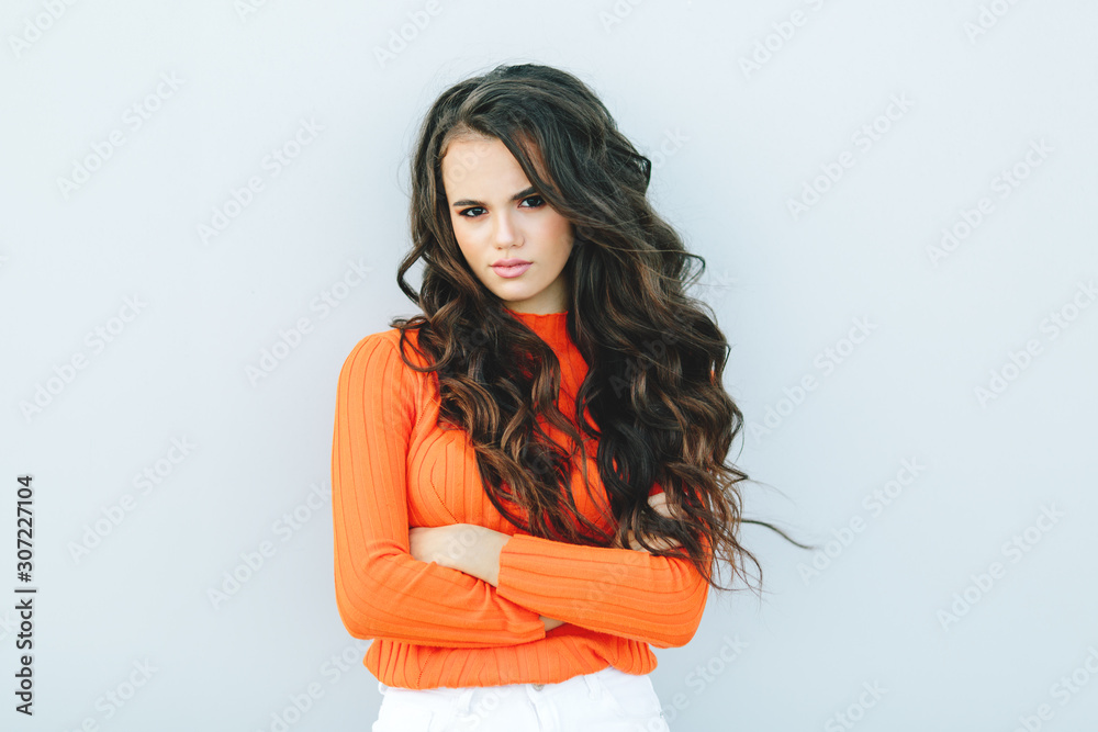 Portrait of angry woman standing with arms folded on gray background. Portrait of angry woman standing with arms folded on gray background.