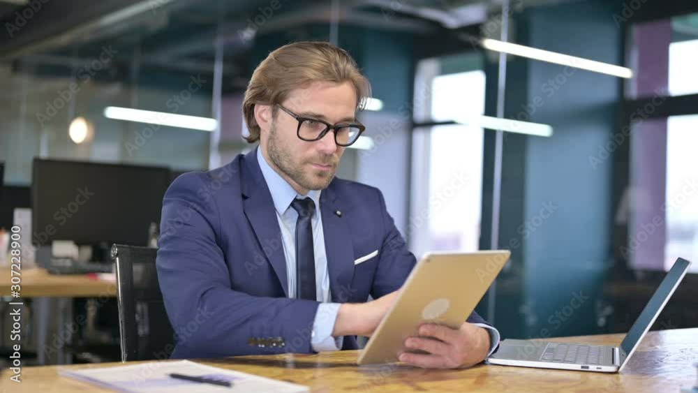 Businessman Using Tablet in Office Businessman Using Tablet in Office