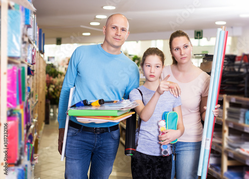 parents with daughter buying school supplies
