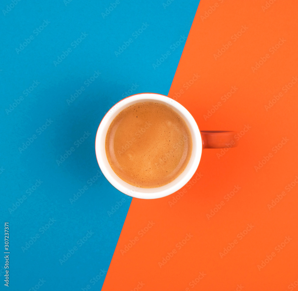Fresh brewed coffee in ceramic cup over orange and blue background. Place for text. - obrazy, fototapety, plakaty 