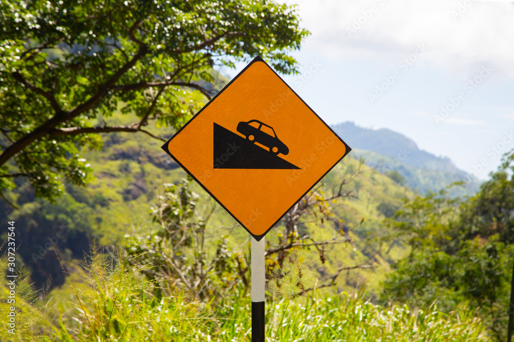 Yellow road sign car down. Steep descent of the road
