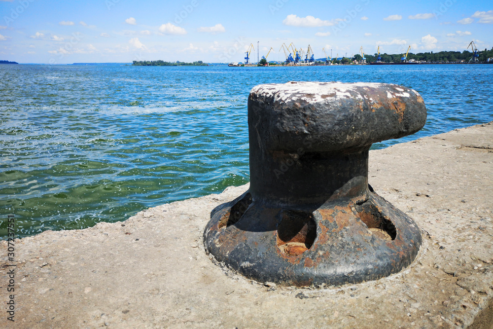 Marine ship mooring bollard on a dock by the waters edge Marine ship mooring bollard on a dock by the waters edge