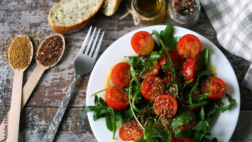 Healthy salad with arugula and cherry tomatoes with mustard sauce. Vegan food.